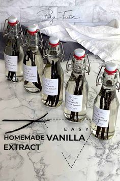 six bottles of homemade vanilla syrup on a marble counter top with labels for each bottle