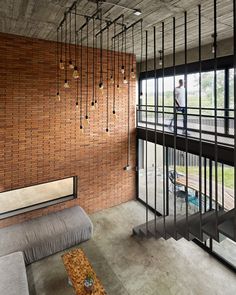 a living room filled with furniture and a brick wall next to a glass sliding door