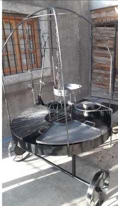 a large metal object sitting on top of a black table next to a building with lots of windows