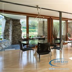 a living room filled with lots of furniture next to a wall covered in glass doors