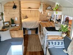 the interior of an rv with wood paneling and white furniture, including a bed