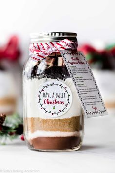 a jar filled with chocolate and marshmallows on top of a white table