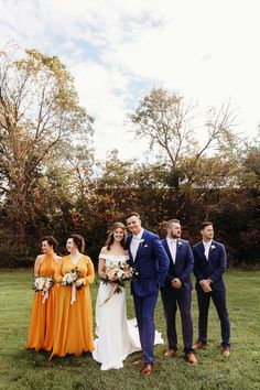 a group of people standing next to each other on top of a lush green field