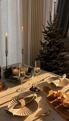 a table set for christmas dinner with wine and bread