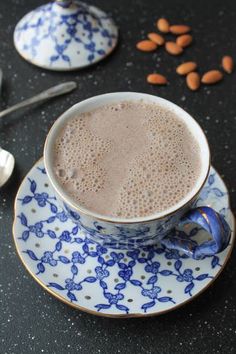 there is a cup of coffee on the saucer with spoons next to it