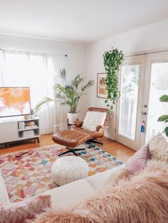 a living room filled with furniture and plants