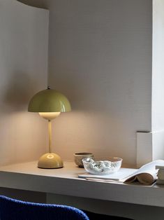 a table with a lamp and bowl on it