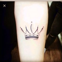 a small tattoo on the leg of a person with a crown tattooed on their arm