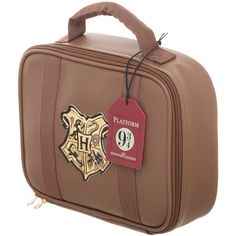 a brown harry potter suitcase with hogwart's crest on it