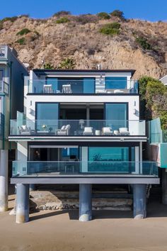 an oceanfront house with glass balconies on the second floor