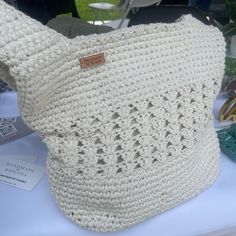 a white crocheted purse sitting on top of a table next to other items