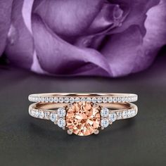 an engagement ring with a pink diamond in the center and side stones on each band