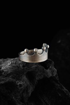 "\"Introducing our exquisite \"\"Crown Ring\"\" - a handcrafted, royal-inspired piece made from 925 Sterling Silver that showcases a regal and elegant design. This unique ring features a detailed crown shape, symbolizing the grandeur and prestige associated with royalty. Made from high-quality 925 Sterling Silver, this luxurious ring is both durable and hypoallergenic, making it suitable for everyday wear. The ring is available in various sizes to accommodate both men and women, making it an out Elegant Silver Ring With Round Crown, Handmade Pinched Crown As A Gift, Handmade Pinched Crown As Gift, Elegant Round Crown For Gift, Wedding Jewelry With High Crown And Crown Design, Silver Jewelry With Structured Crown Design, Handmade Silver Crown Jewelry, Sterling Silver Crown Jewelry, Sterling Silver Crown Rings For Wedding