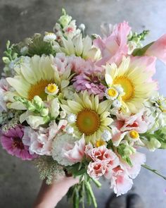 a person holding a bouquet of flowers in their hand