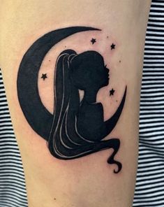 a woman with long hair sitting on top of a crescent shaped moon and star tattoo