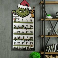 a christmas calendar hanging on the wall next to a shelf filled with books and other items