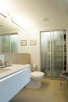 a bathroom with a toilet, sink and shower stall in the middle of the room