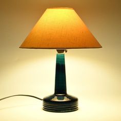 a lamp that is sitting on top of a table next to a light bulb with a brown shade over it