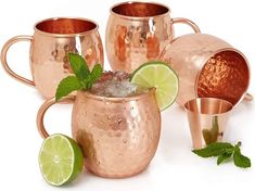 four copper mugs with lime and mint garnishes