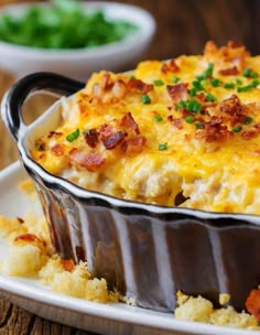 a casserole dish with bacon, cheese and green onions in it on a plate