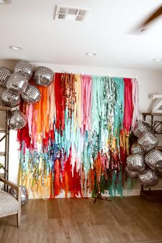 a room filled with lots of disco balls and colorful streamers hanging from the ceiling