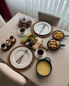 the table is set with plates and bowls of food