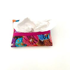 a tissue bag with donuts and sprinkles on it sitting on a white surface