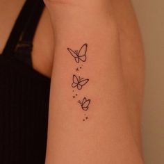 a woman's arm with three butterflies tattoo on the left side of her arm