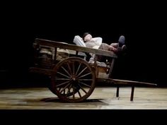 a man laying on top of a wooden cart