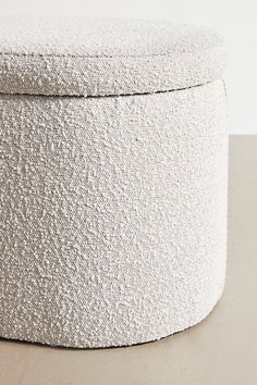 a white round ottoman sitting on top of a table