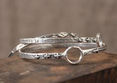 "This beautiful bangle is very unique. It has several different symbols on the outside including the artists' signature cross, three small crosses and a set of angel wings. There is also a small circle that interrupts the flow of the band. The outside is engraved with \"What is seen is temporary...\" on the inside of the bangle the words \"what is unseen is eternal.\" This bangle measures 2 5/8\" in diameter. Solid Sterling Silver Jewelry, Unique Christian, Handmade in Texas by artist Shandon Ca Handmade Silver Promise Bracelets, Spiritual Hand Cast Bracelets As A Gift, Handmade Symbolic Bangle Bracelets, Spiritual Sterling Silver Bangle Cuff Bracelet, Unique Stamped Bangle Bracelets, Formal Spiritual Sterling Silver Bangle, Spiritual Sterling Silver Hallmarked Bangle, Spiritual Nickel-free Bangle Jewelry, Nickel-free Sterling Silver Spiritual Bangle