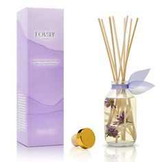 reed diffuser with lavender flowers in glass container next to box and cardboard package on white background