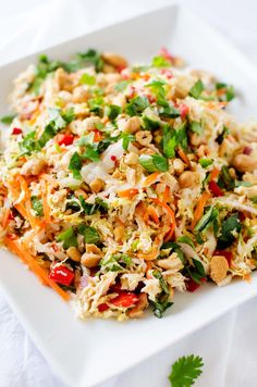 a white plate topped with rice salad and garnished with cilantro leaves