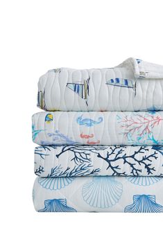 four folded sheets are stacked on top of each other in different colors and patterns, with an ocean theme