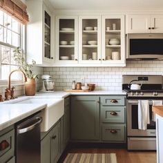 a kitchen with green cabinets and white counter tops