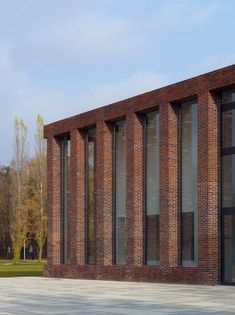 the building is made of red brick and has many windows on each side that are open