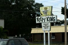 a street sign that says beefy king on it's side in front of a building