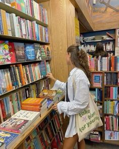 a girl is looking at books in a library