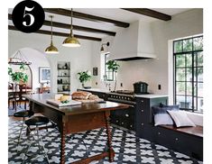 a kitchen with black and white tile flooring next to a dining room table in front of a window