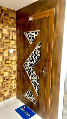 a wooden door with geometric designs on it and a blue mat in front of it