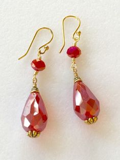 "Beautiful sparkling red Crystal drop earrings featuring 14 x 13 x 10mm faceted iridescent Chinese Crystal teardrop wire wrapped in 14k gold plate with antique gold bead caps and 4x6mm Crystal red rondelle. Earrings hang from simple 14K gold plated ear wires and measure 2\" (5cm) long. Lots of movement and perfect pop of holiday color! A great gift for that special someone or just for you! Also available in silver plate. Please make selection in menu." Crystal Teardrop Earrings, Gold Caps, Holiday Earring, Earrings Crystal, Crystal Drop Earrings, Red Crystals, Christmas Earrings, Crystal Drop, Christmas Jewelry