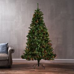 a living room with a couch and a small christmas tree in the middle of it