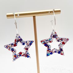 The perfect accessory for your Memorial Day or July 4th celebration.  Silver colored hypoallergenic steel hoop with star shaped resin charm.  Hoops are 25 mm and are lightweight.  Handmade star charm filled with sparkly red, white and blue glitter and confetti pieces.  Get your party on! Patriotic Red Star-shaped Earrings, Patriotic Red Star Earrings, Patriotic Blue Star Jewelry, Patriotic Blue Star-shaped Jewelry, Patriotic Blue Star Shaped Jewelry, Red Star Charm Earrings For Gift, Red Star-shaped Nickel-free Earrings, Nickel-free Red Star Earrings, Multicolor Earrings For Independence Day Gift