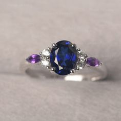 * The delicate ring displays sapphire as main stone. The cluster side stones make the ring similar to the blooming flower . For who wearing this special & delicate ring, will shine like a goddess. ◆ Production Description: Main stone Type: Lab Sapphire Main Stone Shape: Oval Cut Main Stone Size: 6*8mm (1.75ct) Side stone: CZ & Amethyst Metal: 925 Sterling silver - Other options available in the drop down menu ◆ Customization: √Free for Add Engraving √Other Metal Type Available √Other Gem Amethyst And Sapphire Ring, Elegant Multi-stone Sapphire Birthstone Ring, Sapphire Multi-stone Oval Diamond Ring, Elegant Sapphire Multi-stone Birthstone Ring, Elegant Sapphire Birthstone Ring With Multi-stone, Dainty Oval Sapphire Ring For Anniversary, Dainty Sapphire Oval Ring, Oval Purple Sapphire Rings, Purple Sapphire Oval Ring