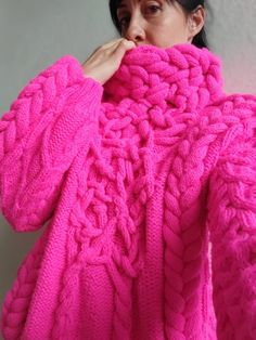 a woman in a pink sweater is covering her face