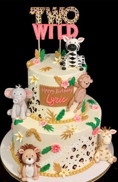 a two tiered birthday cake with animals on it