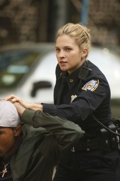 a police officer helping a woman put on her hat