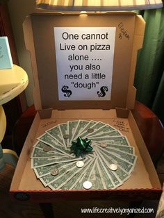 a pizza box with money in it and a sign on the lid that says, one cannot live on pizza alone you also need a little doughnut