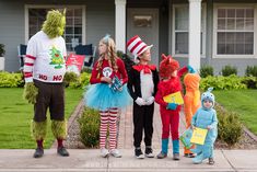 children dressed up in costumes standing on the sidewalk with dr seuss and cat in the hat