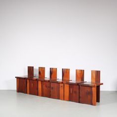 six pieces of wood sitting on top of each other in front of a white wall